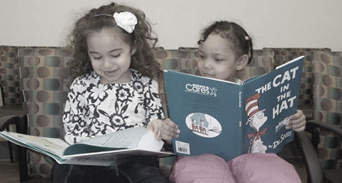 Photo of two young girls reading books